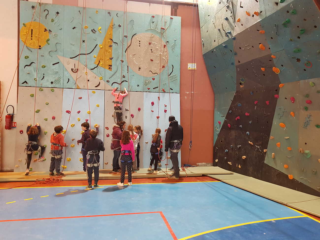 Mur d'escalade avec enfants à l'intérieur du gymnase